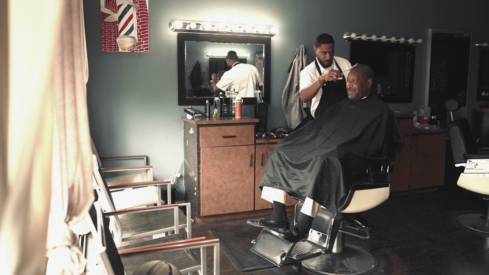 Barber cutting a client's hair in the shop